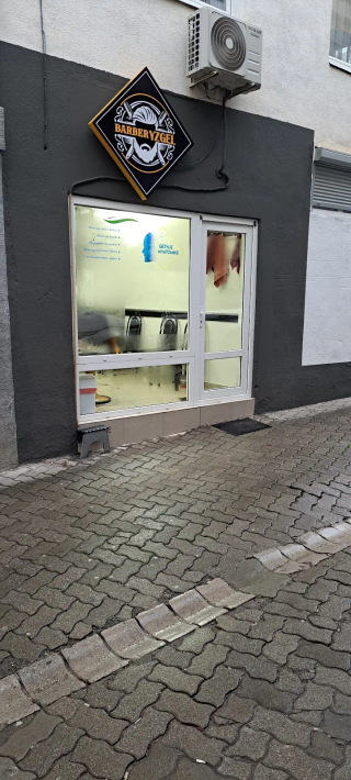 Pamja e jashtme e Barber Yzgel me tabelë diamanti dhe hyrje xhami