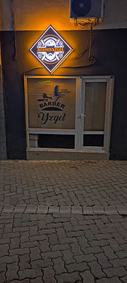 Pamja e jashtme natën me tabelën e ndriçuar BARBER YZGEL