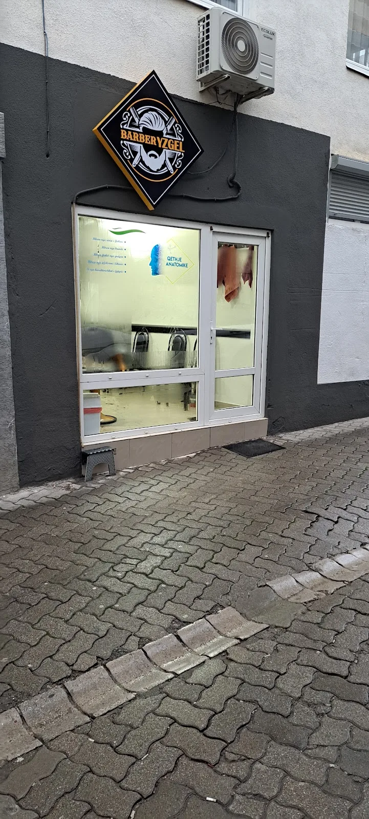 Pamja e jashtme e Barber Yzgel me tabelë diamanti dhe hyrje xhami